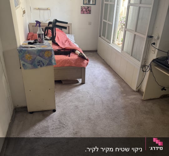 בקבוק תרסיס על שולחן, שואב אבק על מיטה